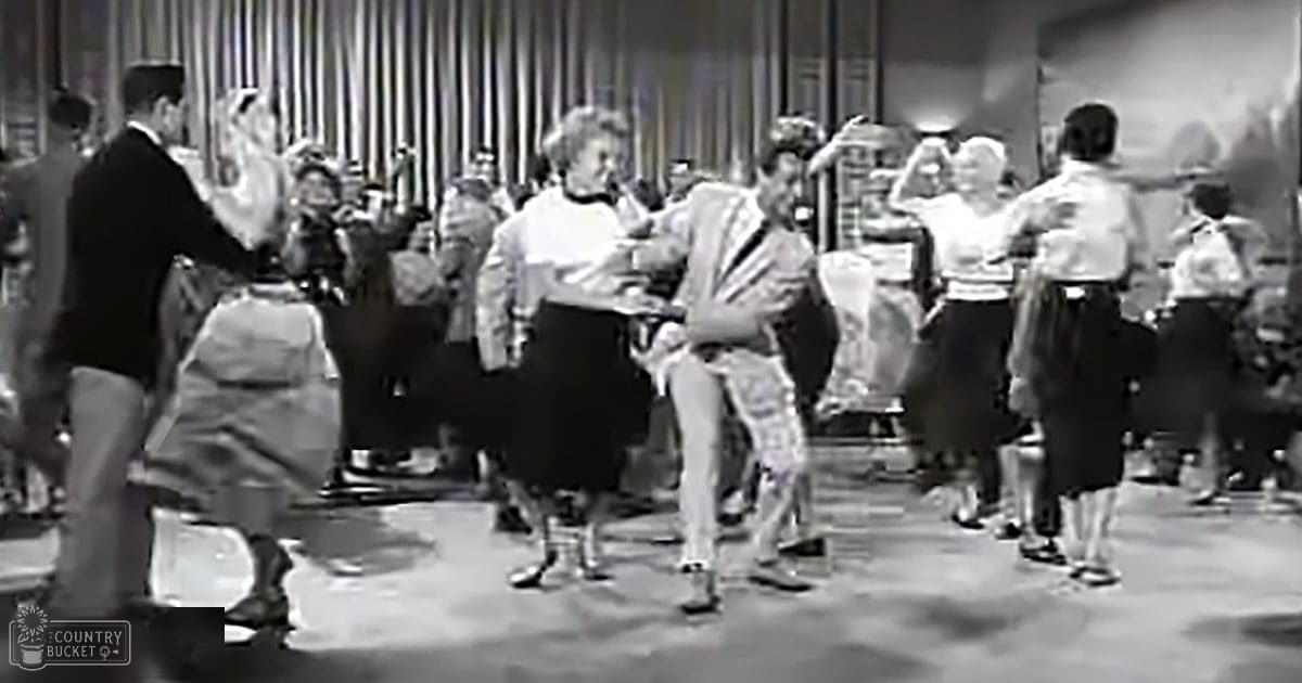 Social dance scene indoors with adults in formal attire, middle-aged to young adults, in a well-lit room.