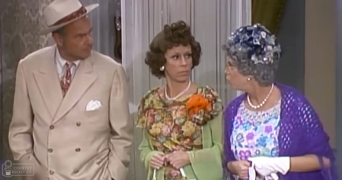 Middle-aged man wearing a beige double-breasted suit with white shirt and patterned tie; two women in floral dresses, one holding a white cloth or napkin.