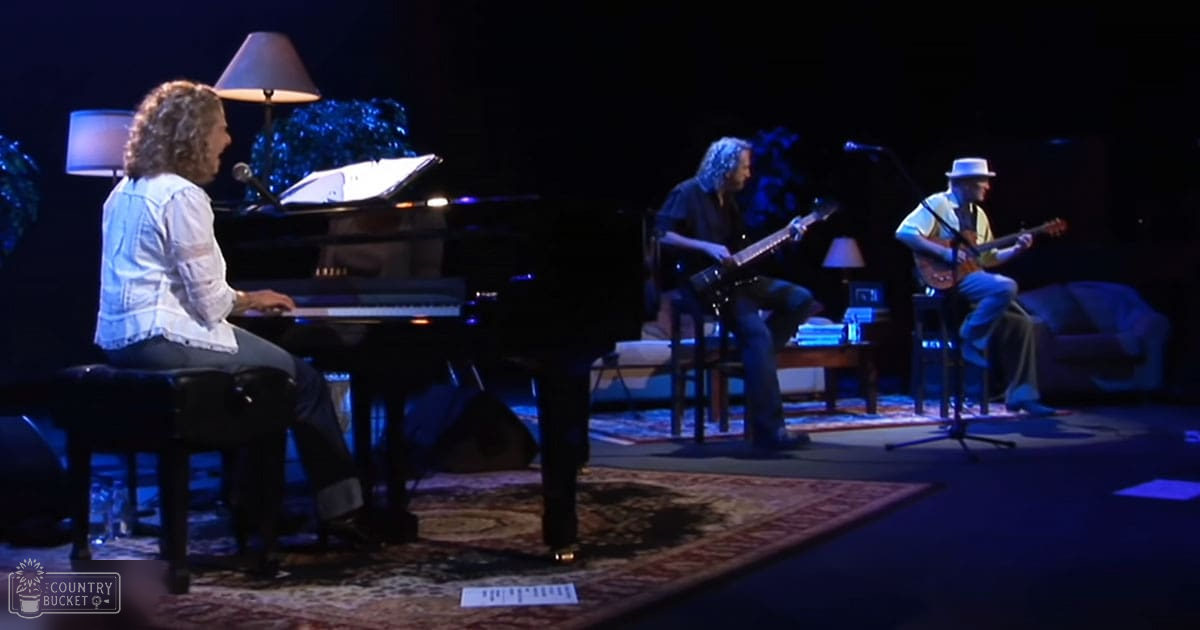 Musical performance in a dimly lit indoor stage with black grand piano, decorative lighting, and formal atmosphere.
