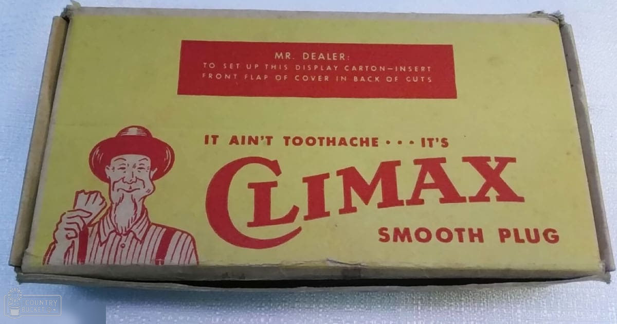 A vintage cigarette carton for Climax Smooth Plug, with a man in a red hat and striped shirt against a plain white background.