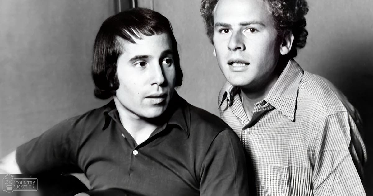 Two young adult males in a casual indoor setting, wearing mid-20th century style shirts with plain walls as background.