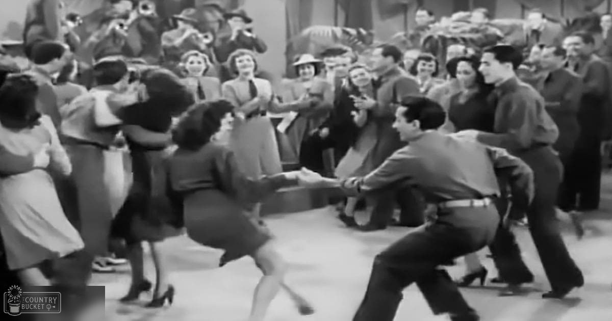 A mid-20th century dance scene with spectators indoors, dressed in formal attire typical of the era.