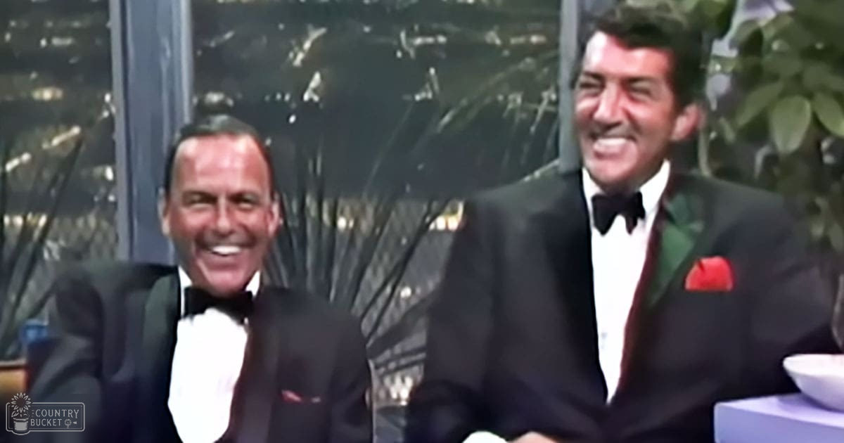 Two adult male singers dressed in formal black tuxedos with white shirts and red pocket squares, possibly at a performance or social event setting.