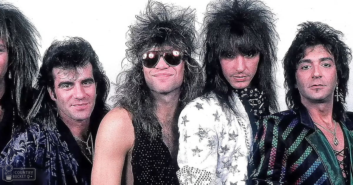 A group photo of a rock band from the 1980s taken in a studio setting with plain white background and controlled lighting.