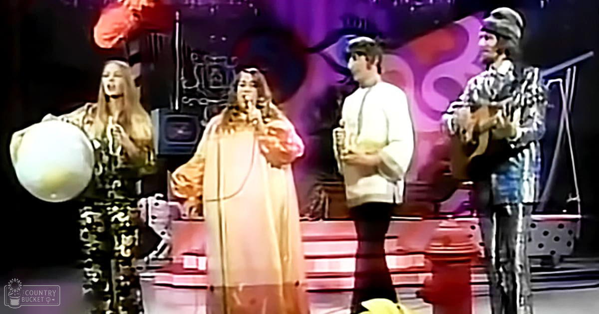 Musical performance in an indoor stage setup with colorful backdrop; spring or summer attire visible.