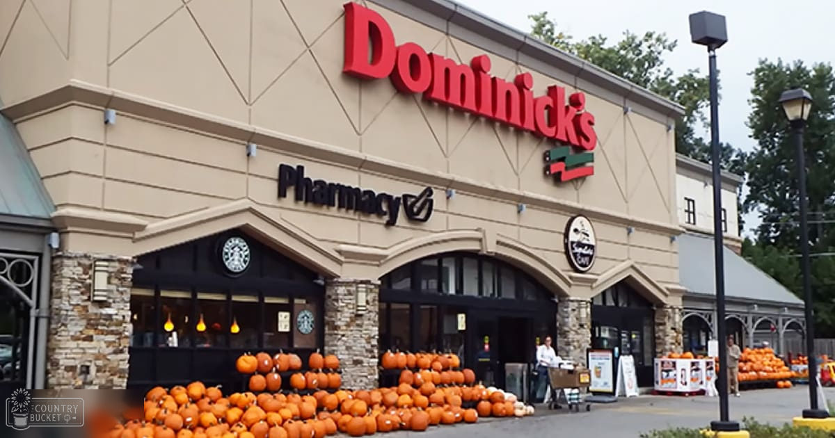 Two adults in an urban Dominick's store, sign visible above entrance with pumpkins outside. Overcast day suggests autumn season.