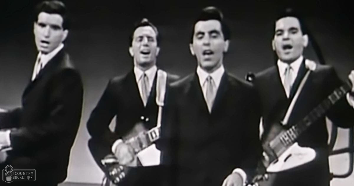 Musical performance group from the mid-20th century in a simple studio backdrop with consistent dark suits and light-colored ties, black-and-white image.