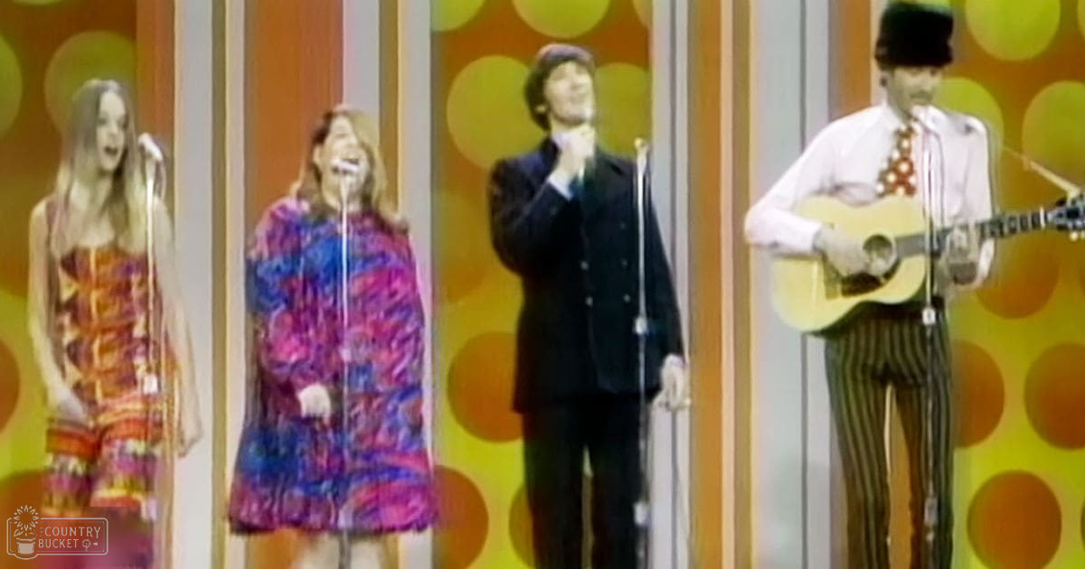 A musical performance with young adult females wearing colorful dresses and a male in vintage attire performing on stage with retro design elements.