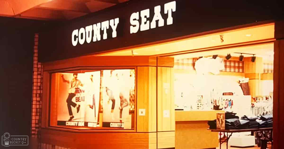 Retail store with mannequins displaying retro-style clothing, warm tones, and 'COUNTY SEAT' signage.