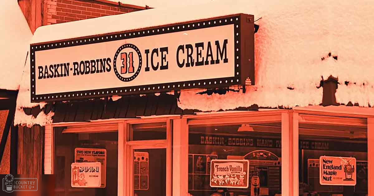 Snow-covered urban landscape with Baskin-Robbins ice cream shop signage indicating cold weather conditions, daytime natural sunlight.