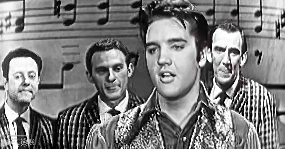 A young adult male performer in patterned shirt, surrounded by three other adults dressed formally on a stage with musical notes backdrop.