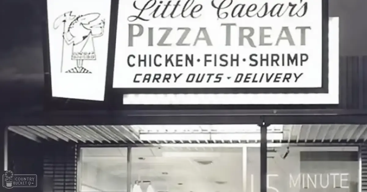 Sign for Little Caesar's Pizza Treat with offerings listed at a nighttime storefront, black and white monochrome