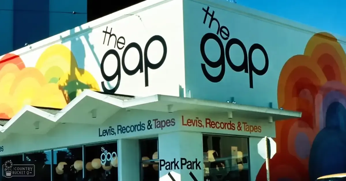 Urban storefront with colorful cloud-like decorations under clear daylight; signage for 'The Gap' advertising Levi's, Records & Tapes.