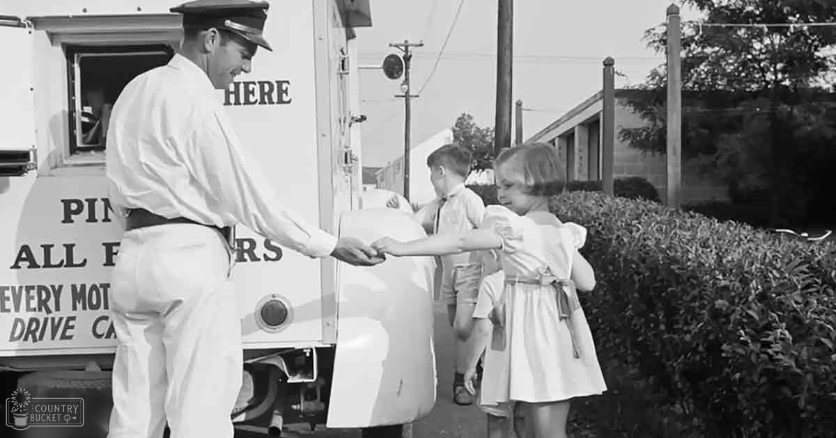 A middle-aged male in a mid-20th-century uniform interacts with two young children at an agricultural service drive-thru, surrounded by greenery and natural daylight.
