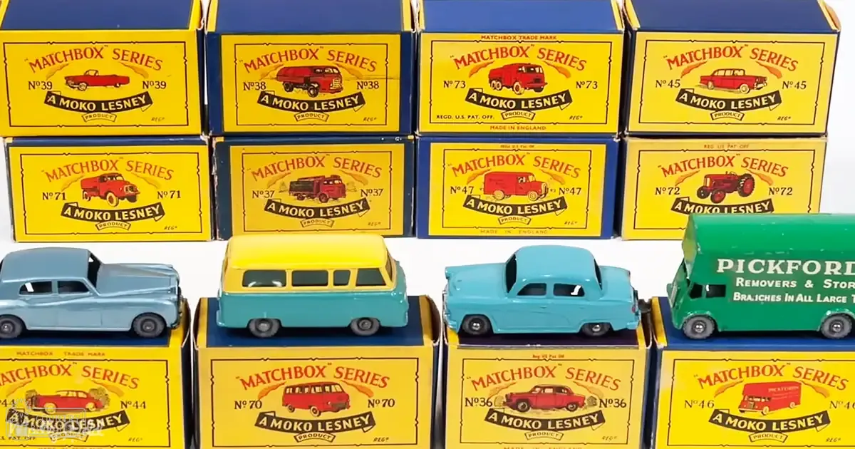 Matchbox toy car boxes with corresponding models, including a blue sedan, yellow van, light blue pickup truck, and green delivery van labeled 'Pickford Removers & Storage', displayed indoors under artificial lighting.