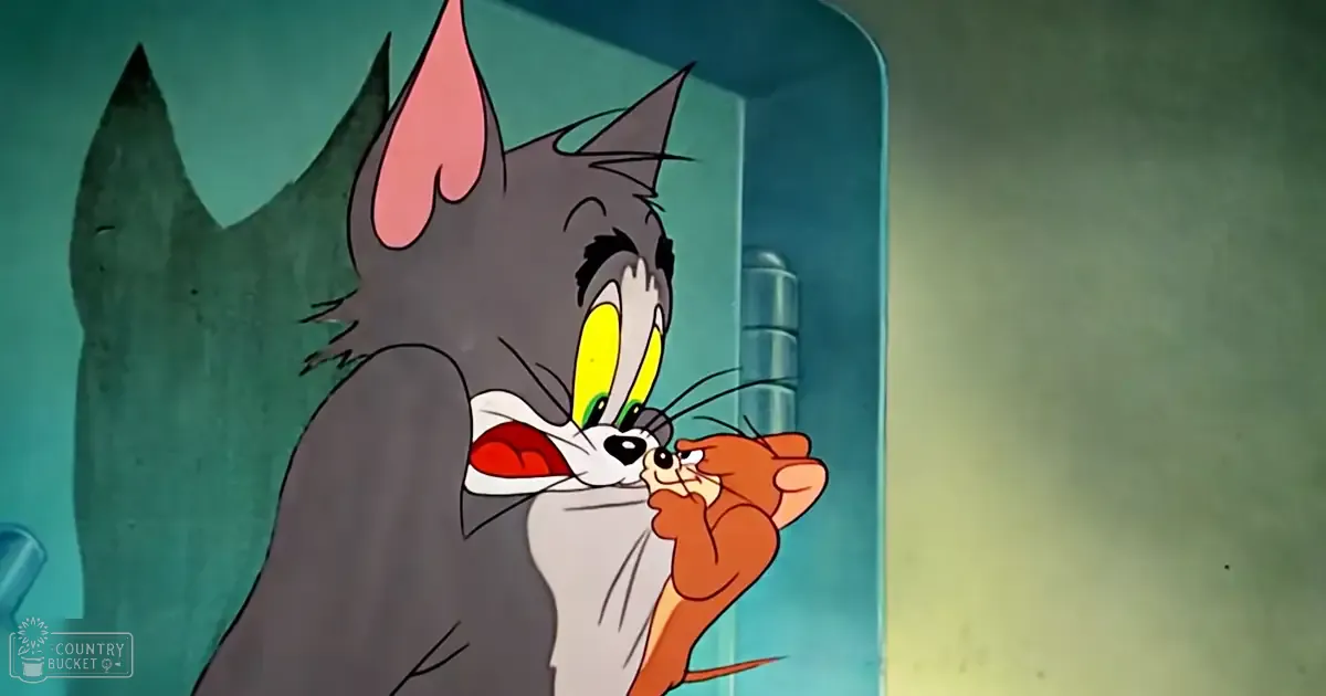 A gray cat with yellow eyes interacts with a small brown mouse indoors, muted lighting, shades of gray, yellow, brown, teal, and greenish-blue tones.