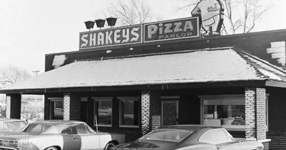 Shakey's Pizza Parlor, urban area, winter season, daytime, classic cars from the 1950s or early 1960s with rounded shapes and chrome details.