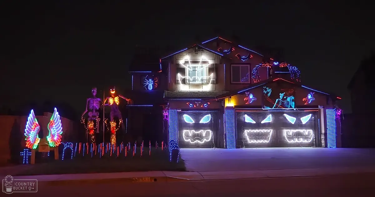 Halloween-themed residential neighborhood with spooky decorations, glowing lights, and eerie designs at night.
