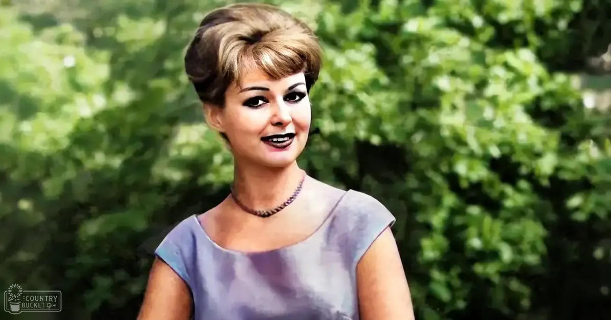 A young adult female wearing a form-fitting, sleeveless light purple dress with cap sleeves and a round neckline, accessorized with a necklace in an outdoor setting during spring or summer.