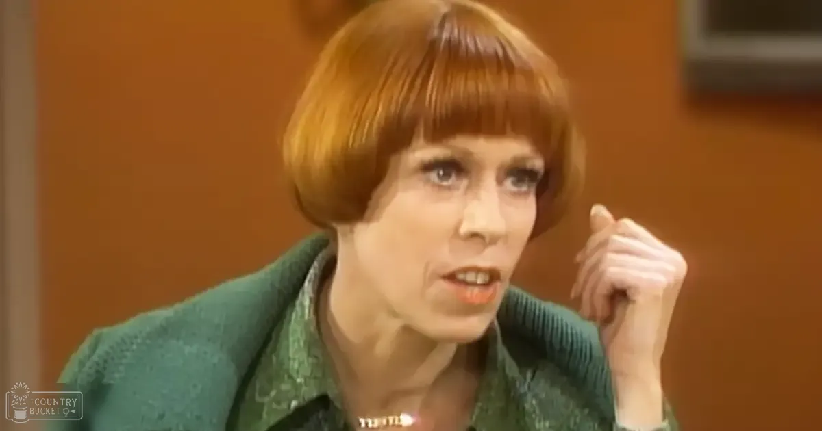 A middle-aged woman in a textured green jacket with a high neckline, indoors, wearing a necklace.