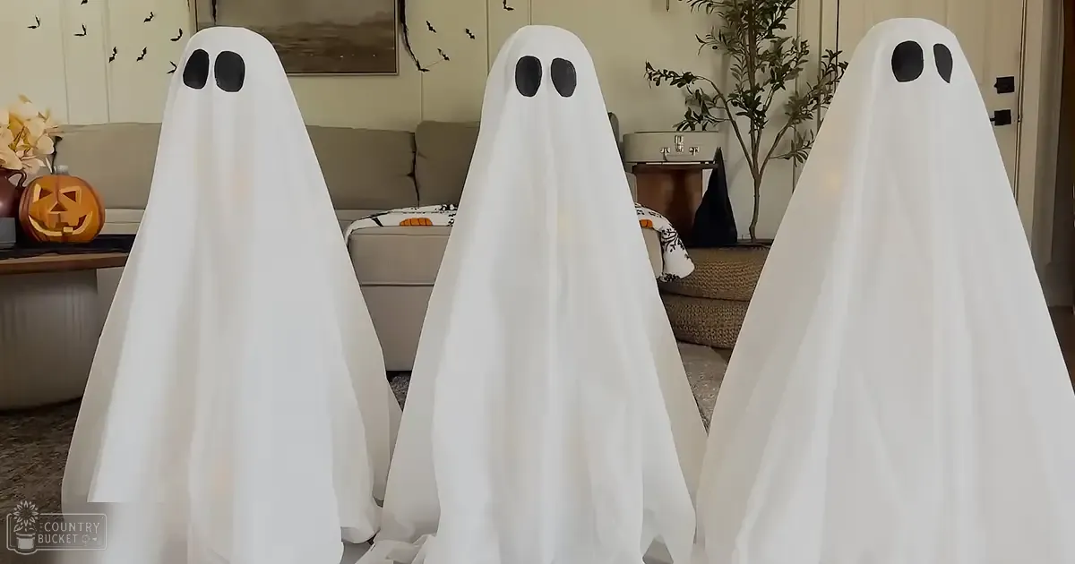 Three ghostly figures in a cozy, decorated living room for Halloween with natural light.