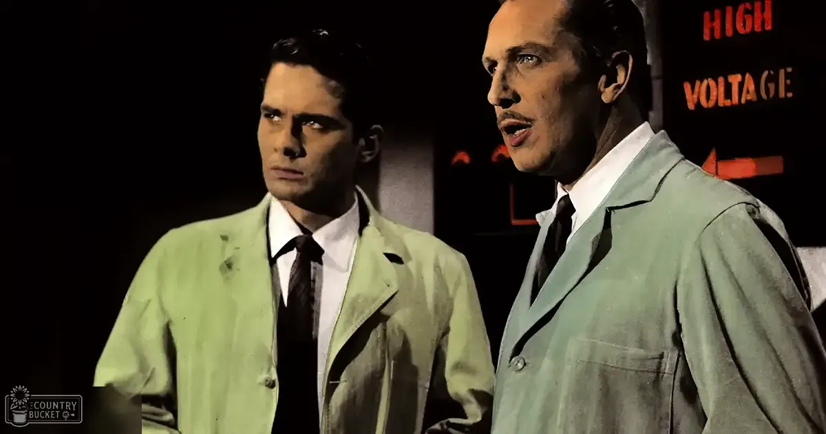 Two men in a dimly lit room with 'HIGH VOLTAGE' signage visible, dressed in mid-20th century attire.