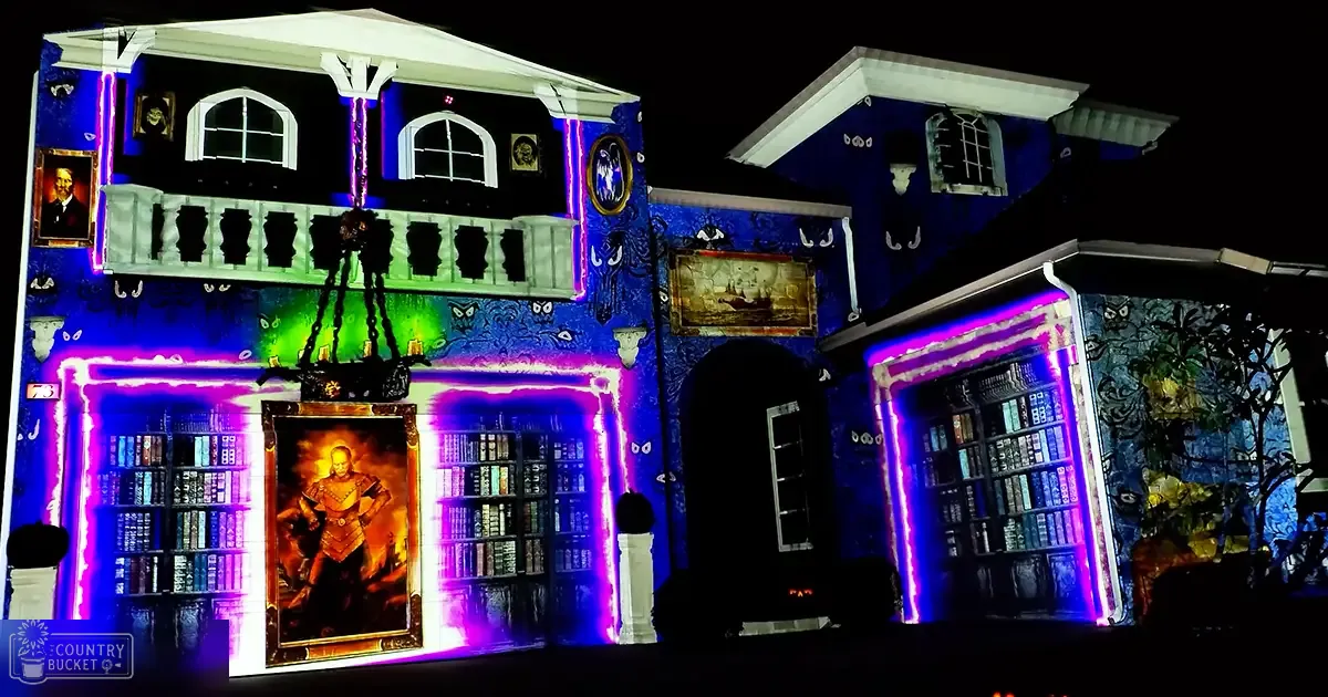 A suburban neighborhood decorated with Halloween lights and bookshelves at night.