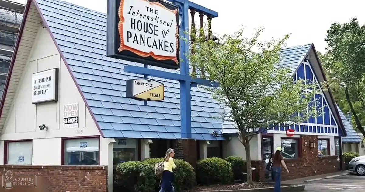 Urban area with 'The International House of Pancakes' restaurant, spring or summer trees, daytime light.