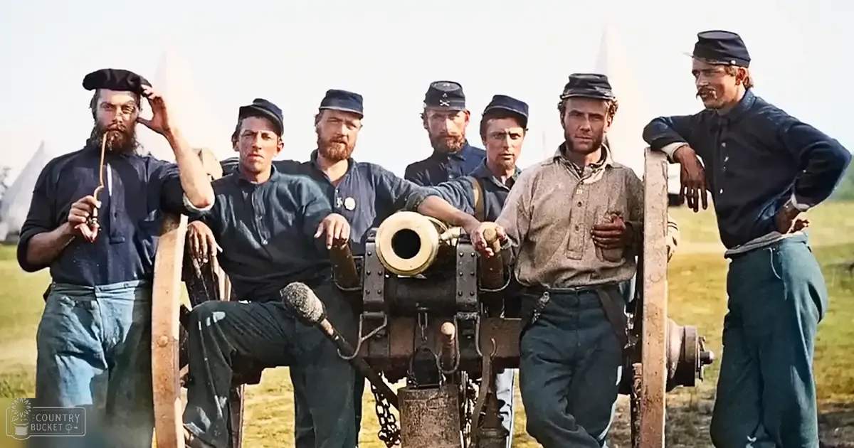 A group of Civil War-era soldiers with a cannon in an open field, likely during the American Civil War.