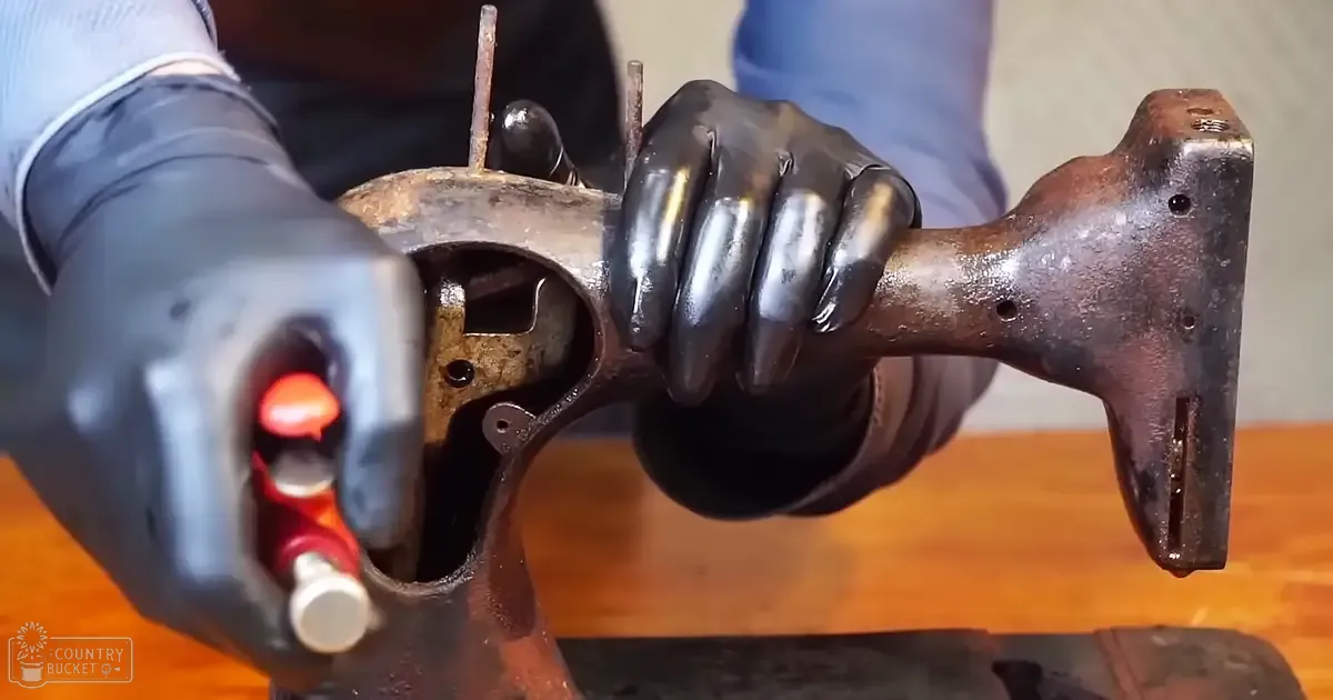 Rusty metal mechanical part with holes and protrusions being worked on indoors.