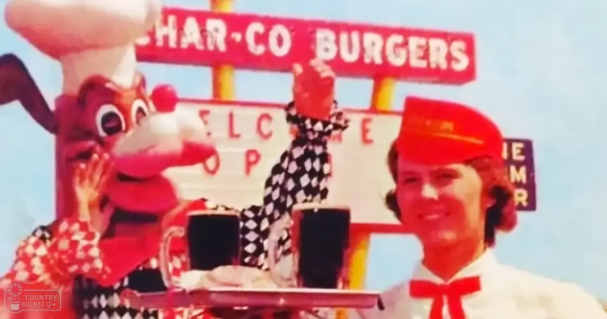 Promotional float for Char-Co Burgers with young adults in red and white checkered dresses, a child in black and white checkered dress, an adult male in white shirt with red accents and bow tie, set against outdoor festival backdrop.