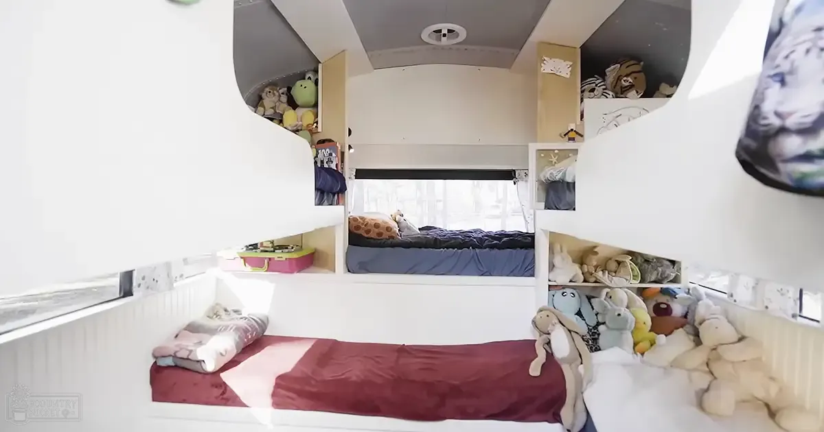 Child's bedroom with bunk beds, stuffed animals, and natural light.