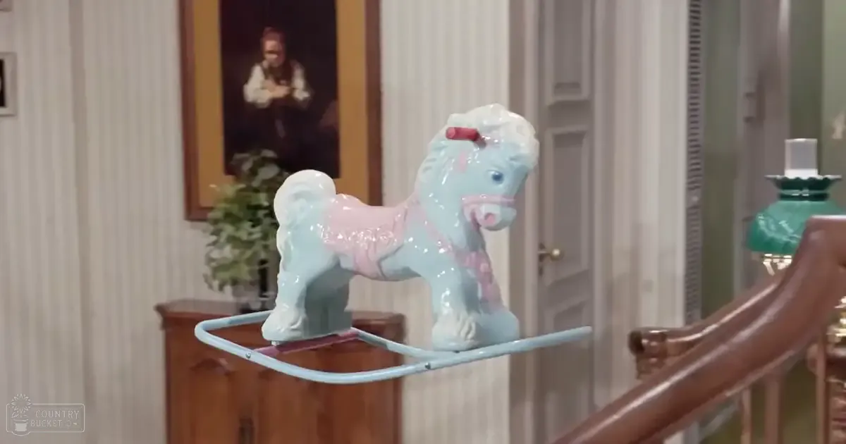 A ceramic rocking horse with pastel colors indoors in a home setting