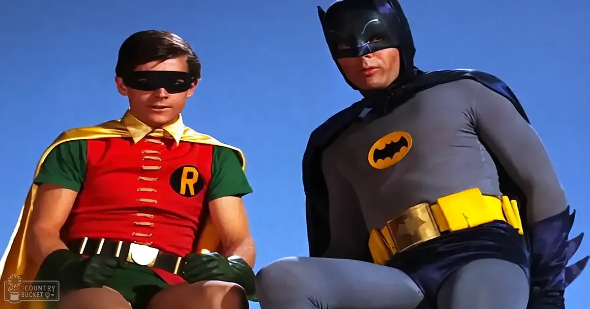 Batman and Robin in an outdoor setting with a clear blue sky, likely summer day.