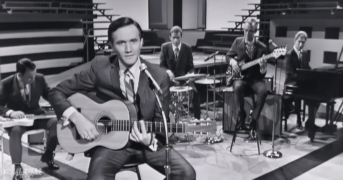 Adult male musicians in a studio setting with microphones, drums, and grand piano.