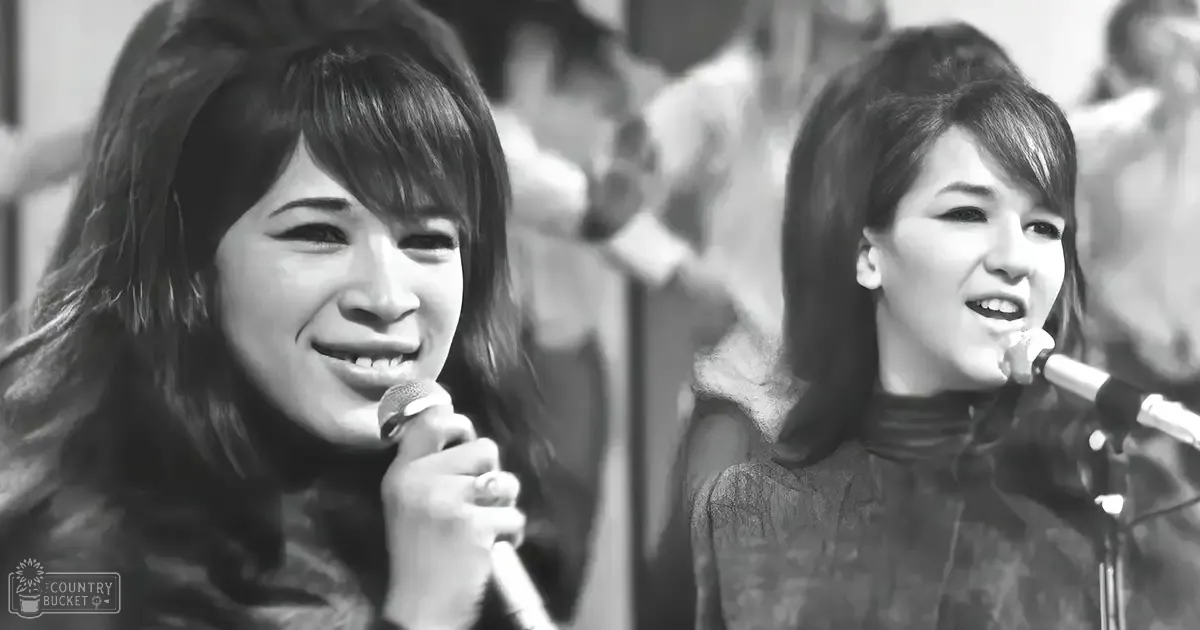Two young adults performing at a music event indoors with bright, even lighting.