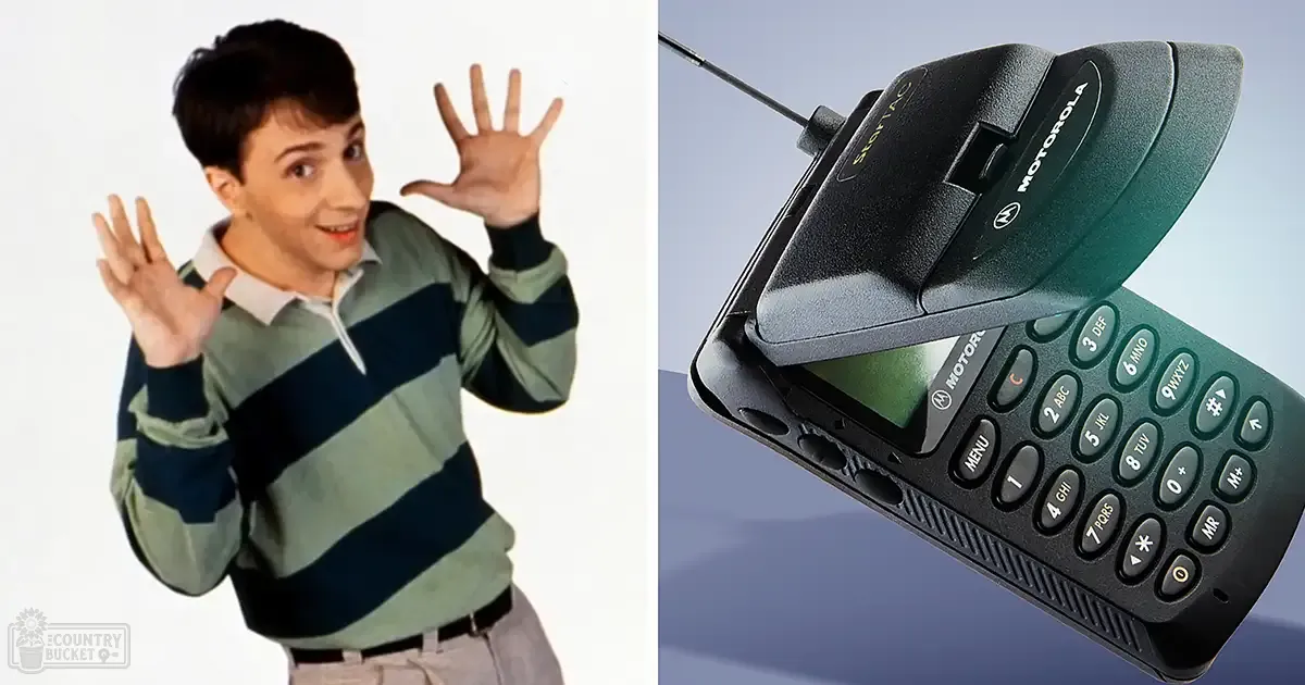 A young adult male in a striped long-sleeve polo shirt from the mid-1980s to early 1990s, holding a Motorola StarTAC flip phone against a plain white background.