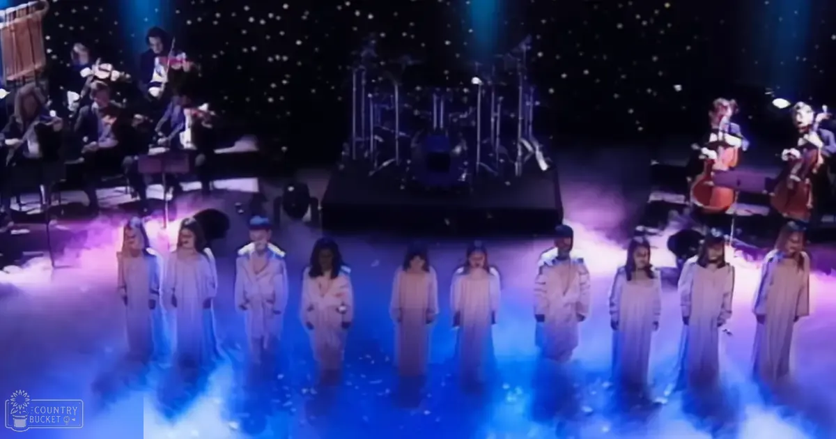 A choir and orchestra performing on stage in a concert hall at night.