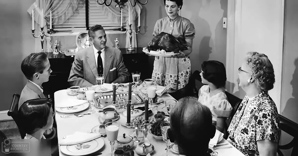 A family gathering around a dining table set for what appears to be a holiday meal in an indoor home dining room with fall decor, natural or soft artificial light.