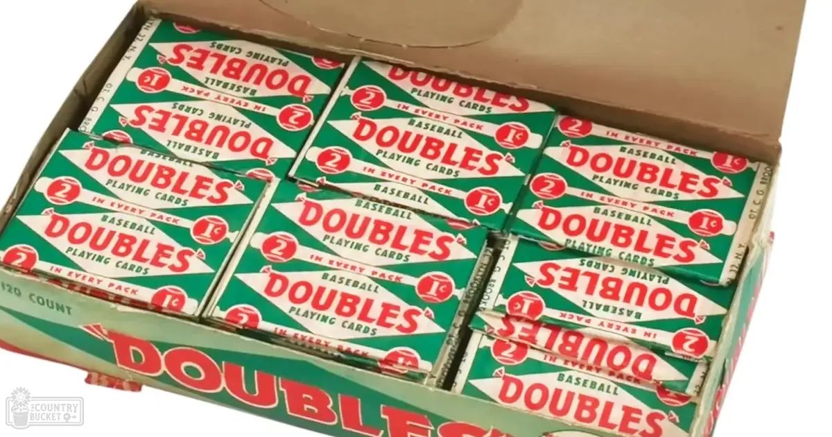 A cardboard box filled with packs of "Doubles" baseball playing cards sits on a plain background indoors.