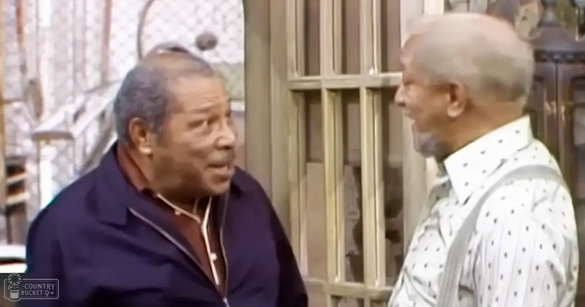 Two older adult males wearing vintage-style clothing indoors in a residential setting during daytime.