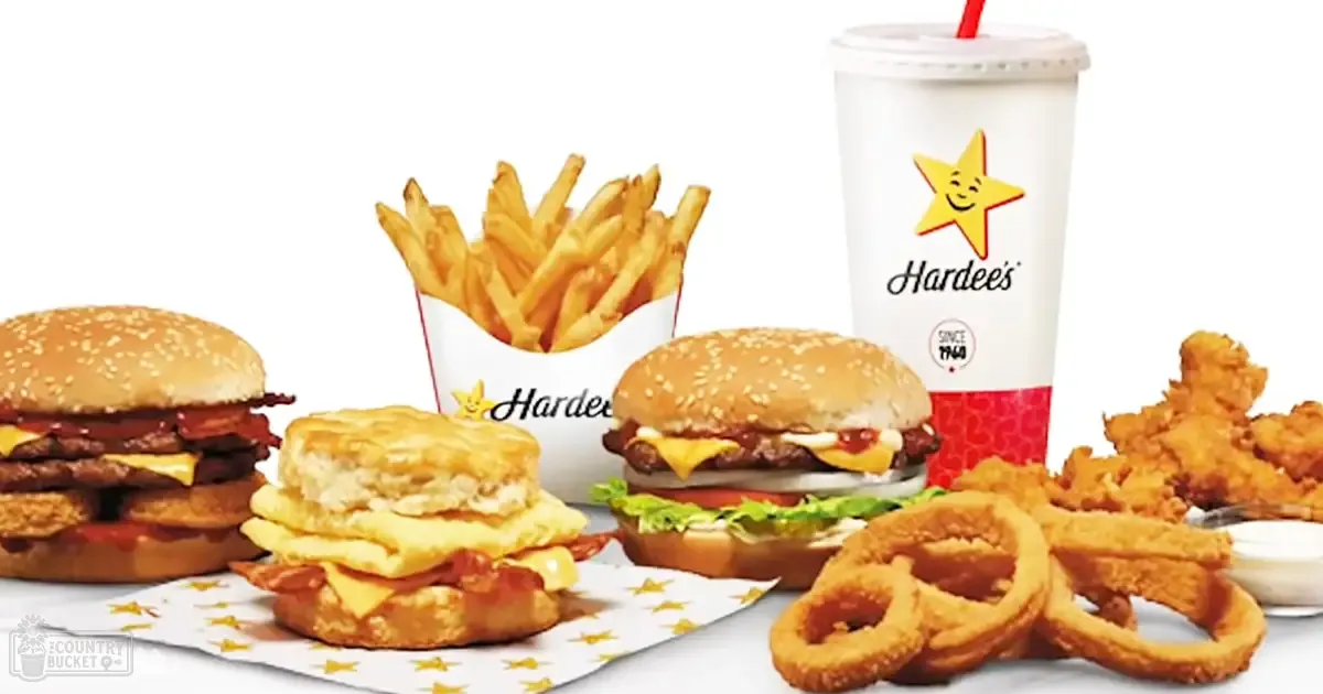 Hardee's meal display with burgers, fries, chicken pieces, and dipping sauce in a studio setting with white background.