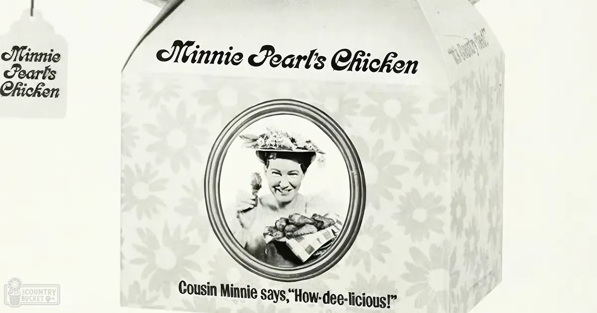 A woman holding a basket labeled 'Minnie Pearl's Chicken' with text reading 'Cousin Minnie says, "How-dee-licious!"', wearing a floral hat and checkered dress in an indoor setting.