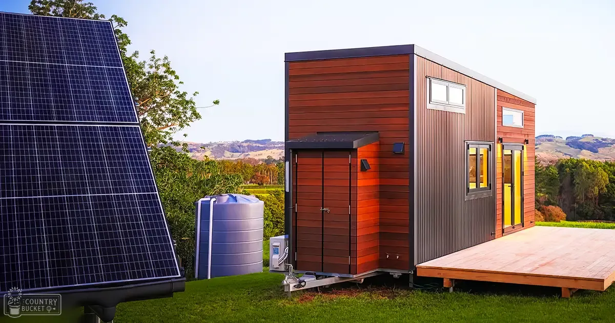 A modern tiny house with solar panels amidst rolling hills and clear skies at late afternoon or early evening.