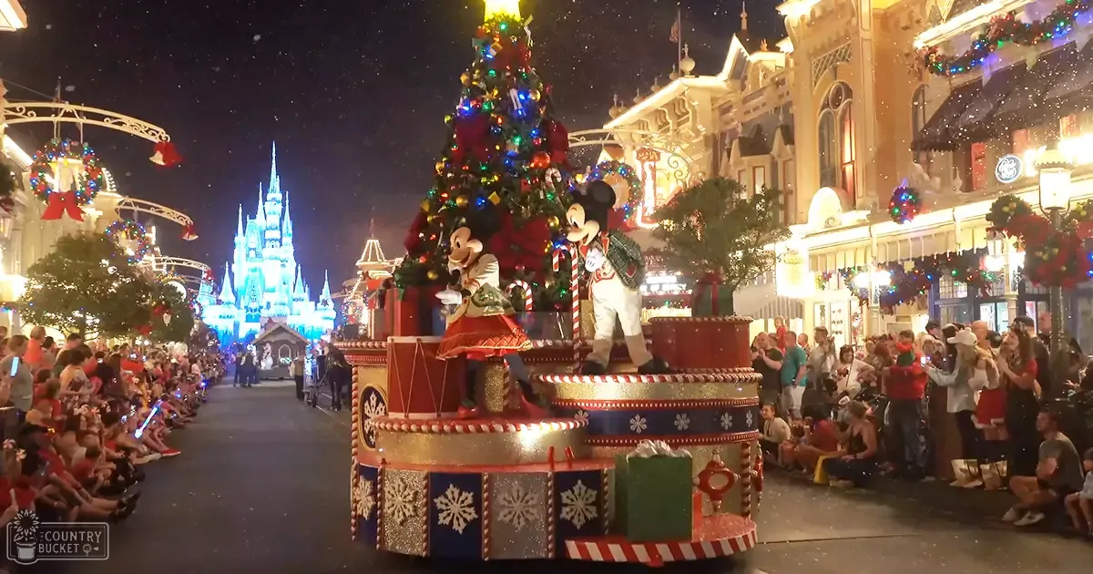 A festive Christmas parade at Disney World with Mickey Mouse and Minnie Mouse, with children in holiday-themed outfits and adults dressed casually for a theme park visit.