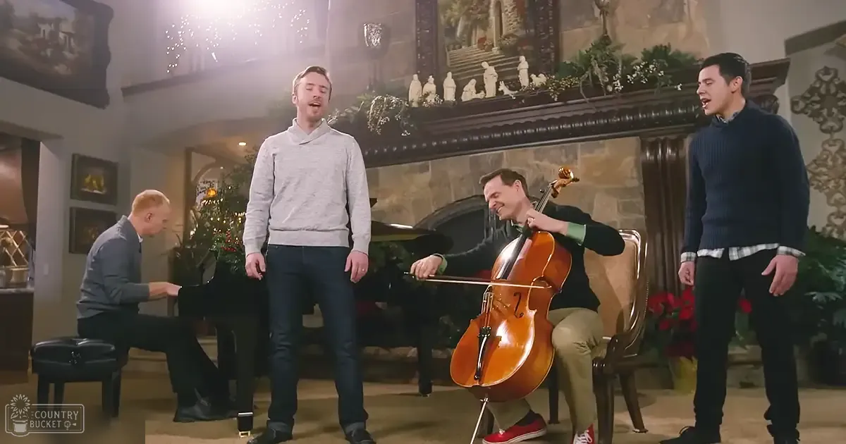 A group performance in an indoor setting with ornate decor, including a grand piano, chairs, framed artwork on walls, Christmas wreaths, and garlands. The room is decorated for the holiday season.