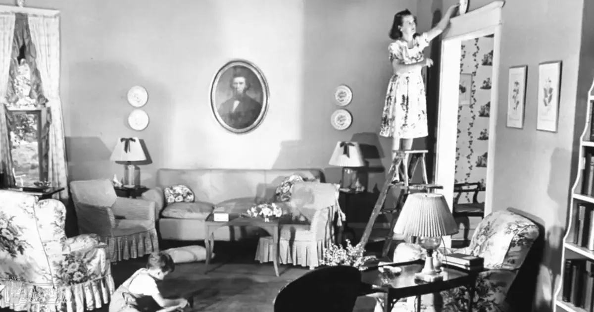 A woman painting in her cozy mid-20th century living room with floral-patterned furniture and home decor, natural light, black-and-white