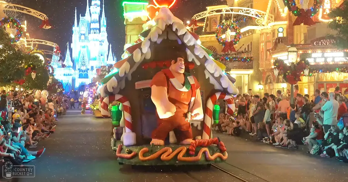 A festive parade scene with children in brightly colored outfits and adults watching in front of Cinderella Castle adorned for Christmas.