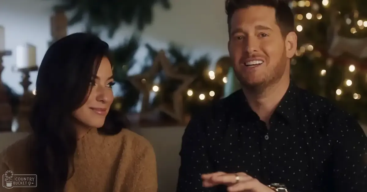 A couple in a cozy indoor setting with string lights and star-shaped ornaments, suggesting a festive holiday atmosphere.