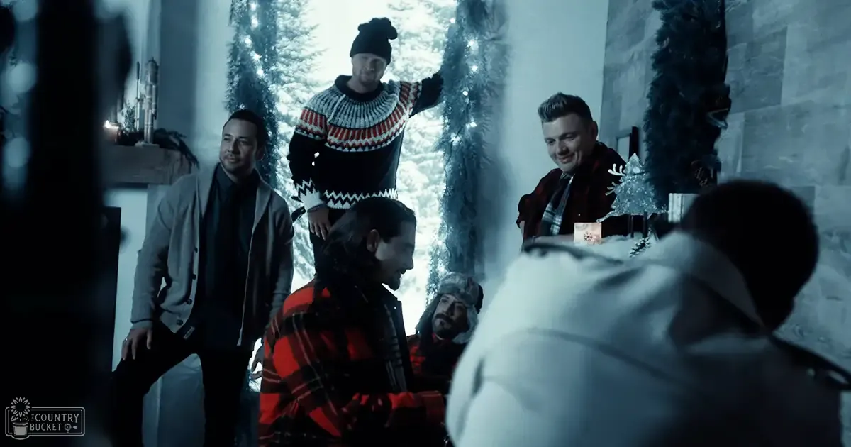 Group of adults in festive indoor setting during winter, wearing woolen clothing and scarves.
